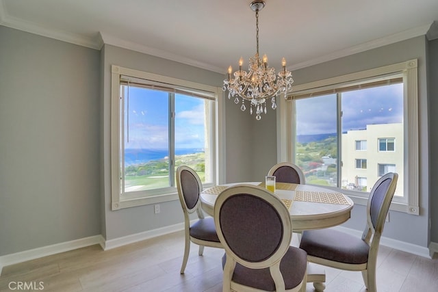 dining space featuring an inviting chandelier, baseboards, crown molding, and light wood-type flooring