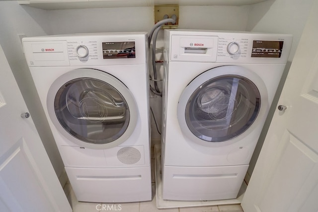 laundry area with tile patterned floors, laundry area, and washing machine and dryer