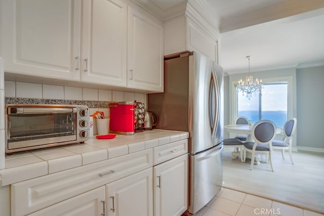 kitchen with a toaster, decorative backsplash, an inviting chandelier, and white cabinets
