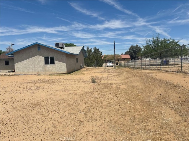 view of yard with central AC and fence