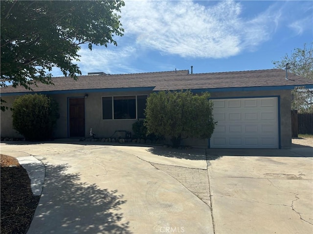 ranch-style house with stucco siding, driveway, and an attached garage
