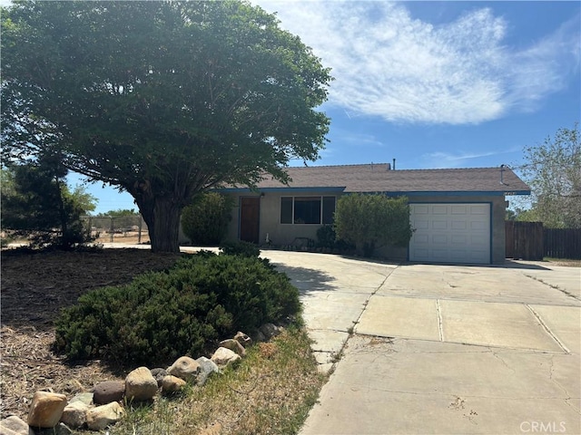 ranch-style home with fence, concrete driveway, and an attached garage