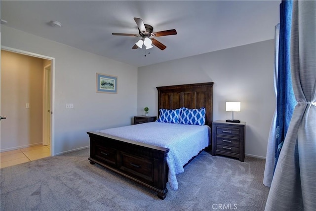 bedroom featuring light tile patterned flooring, a ceiling fan, light colored carpet, and baseboards