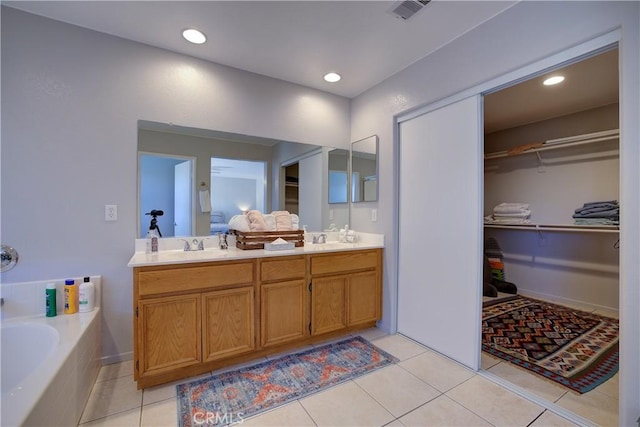 full bathroom with tile patterned flooring, double vanity, a sink, visible vents, and a garden tub