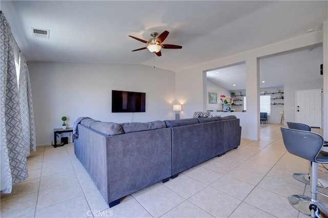 living area with visible vents, ceiling fan, light tile patterned flooring, and vaulted ceiling
