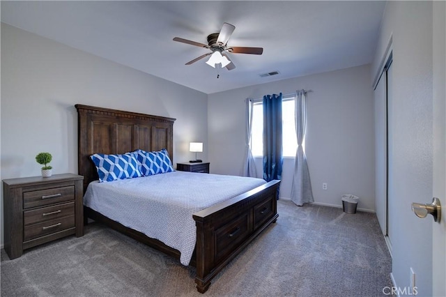 bedroom with a closet, a ceiling fan, visible vents, light carpet, and baseboards