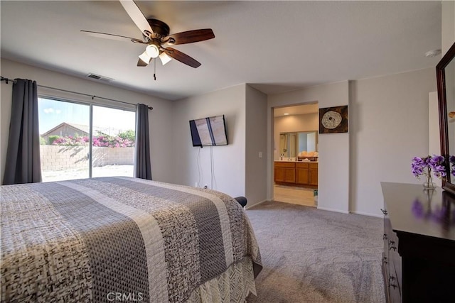 carpeted bedroom featuring baseboards, visible vents, ceiling fan, and ensuite bathroom