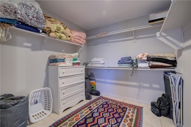 walk in closet with light tile patterned floors