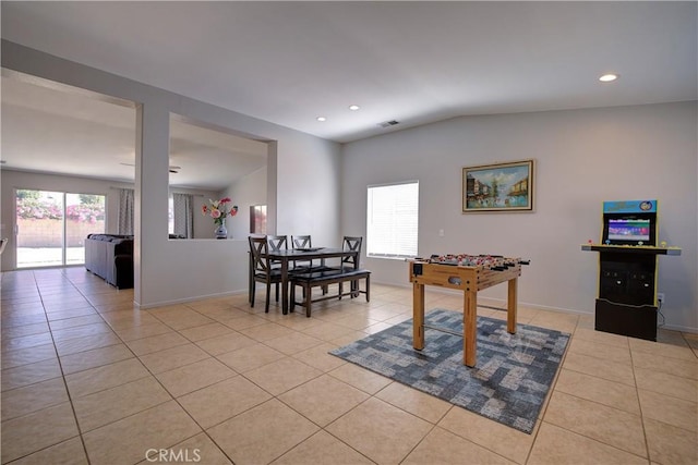 dining space with baseboards, light tile patterned floors, a healthy amount of sunlight, and vaulted ceiling