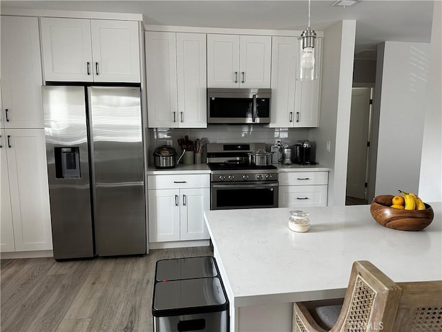 1941 Mentone Ave, Pasadena, CA 91103 - kitchen featuring decorative light fixtures, white cabinetry, stainless steel appliances, and light wood-style floors