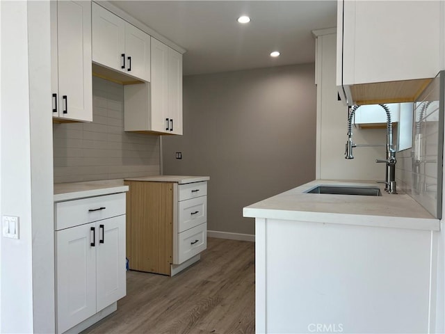 1941 Mentone Ave, Pasadena, CA 91103 - kitchen with decorative backsplash, a sink, light countertops, light wood-type flooring, and recessed lighting
