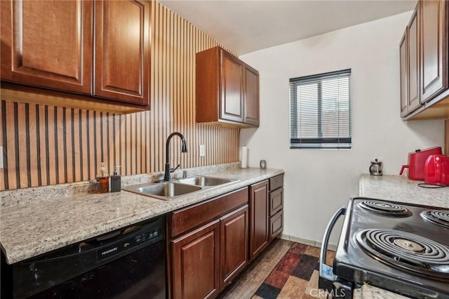 kitchen with dark wood-style floors, black appliances, a sink, and light countertops