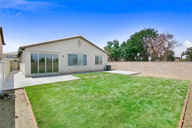 rear view of property featuring a fenced backyard, a patio, stucco siding, and a lawn