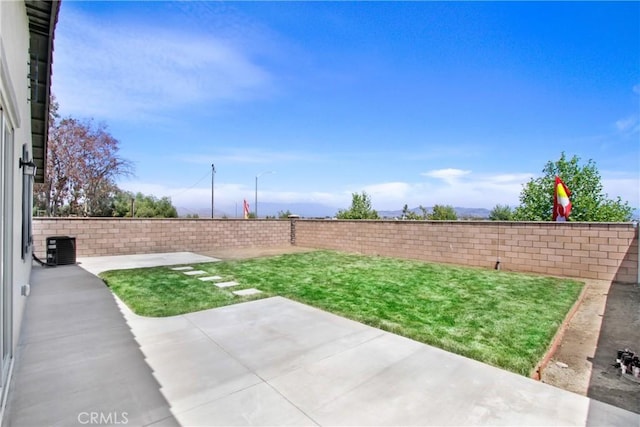 view of yard featuring a fenced backyard, cooling unit, and a patio area