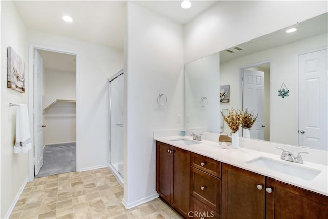 full bathroom featuring a sink, a stall shower, recessed lighting, and double vanity