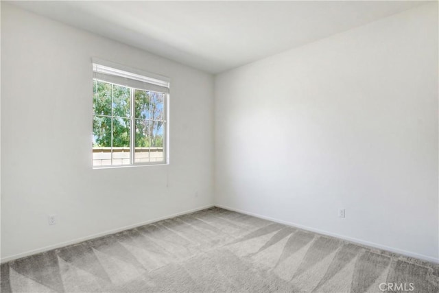 empty room with baseboards and light carpet