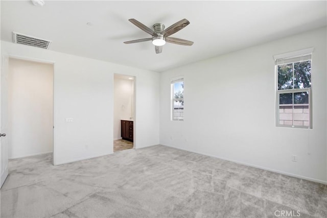 empty room featuring baseboards, ceiling fan, carpet, and visible vents