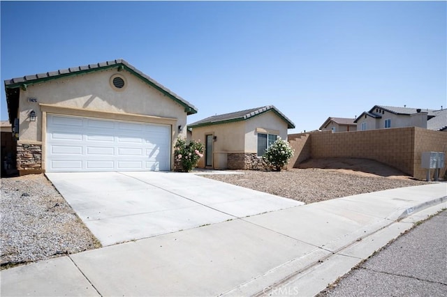 13025 Glendale Pl, Victorville, CA 92392 - view of front of home with stucco siding, driveway, stone siding, and a garage