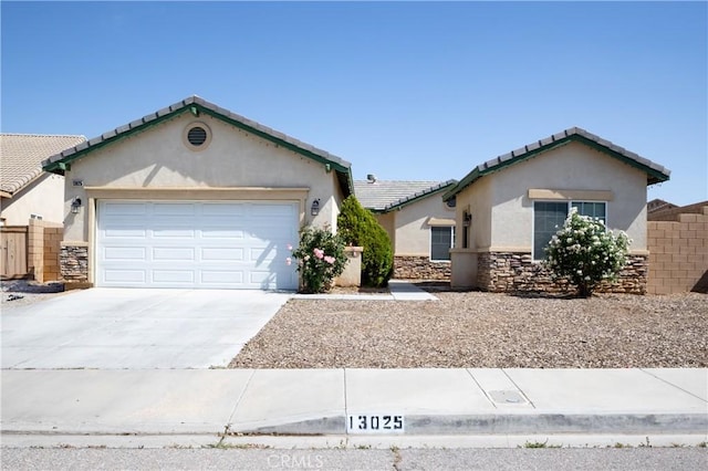 13025 Glendale Pl, Victorville, CA 92392 - view of front of house featuring stucco siding, a garage, stone siding, a tile roof, and driveway