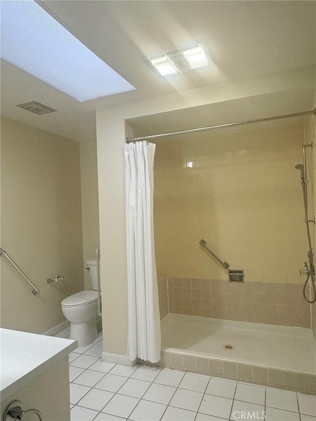 full bath with toilet, a tile shower, and tile patterned floors