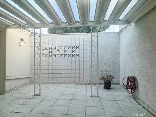 basement with light tile patterned flooring, visible vents, and plenty of natural light