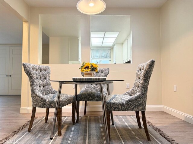 dining room featuring wood finished floors and baseboards