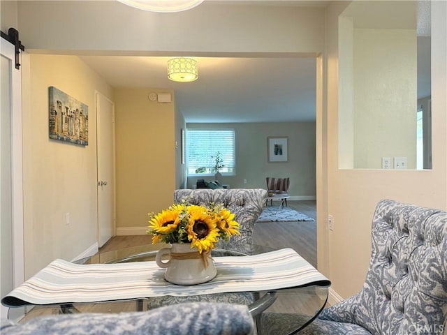 dining space with baseboards and a barn door