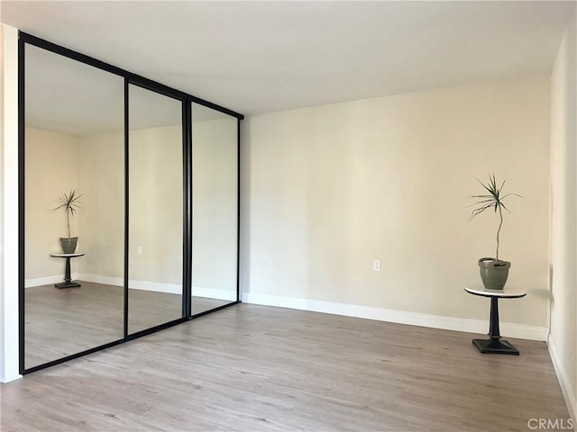 interior space with baseboards and wood finished floors
