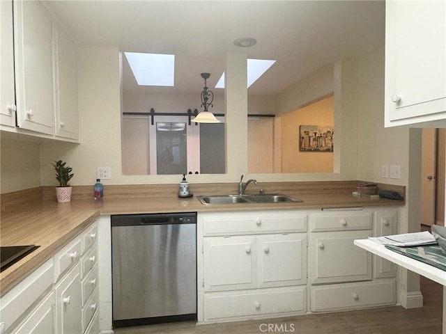 kitchen with a skylight, dishwasher, white cabinets, and a sink