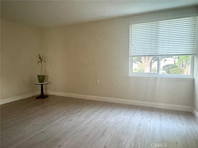 spare room featuring wood finished floors and baseboards
