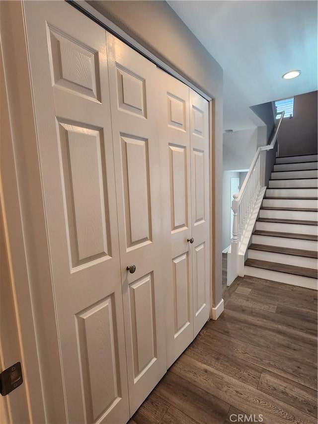 corridor featuring dark wood-type flooring and stairway