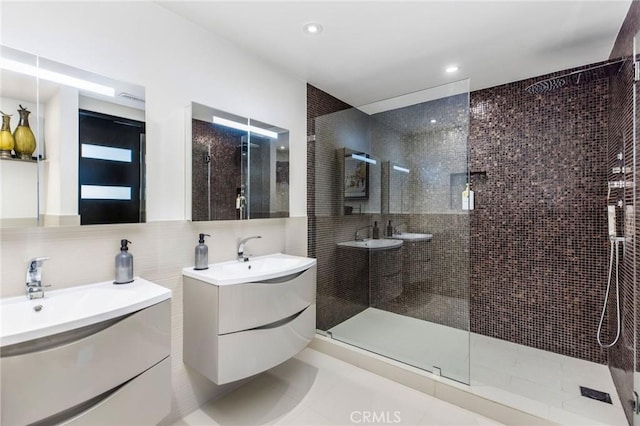 full bath with recessed lighting, two vanities, a shower stall, and tile patterned floors