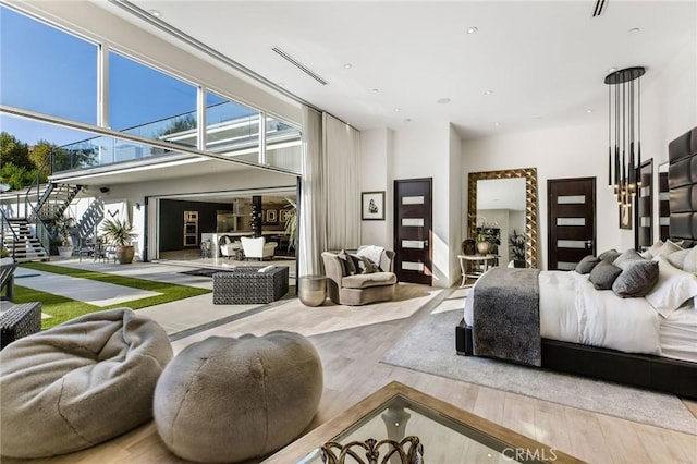 bedroom featuring a towering ceiling, wood finished floors, recessed lighting, and visible vents