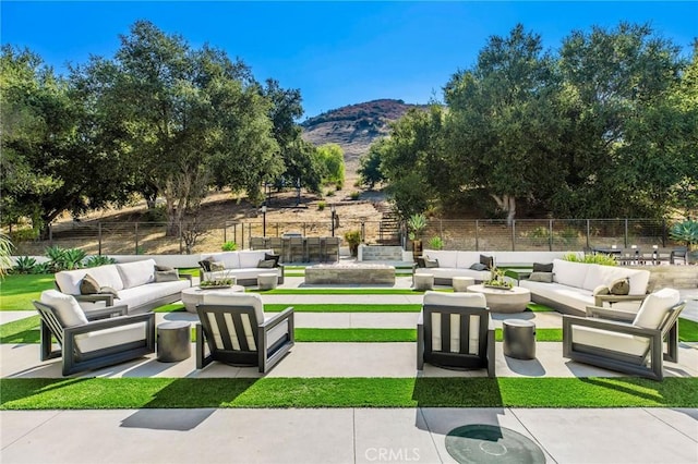 view of patio / terrace featuring a mountain view, an outdoor hangout area, and fence