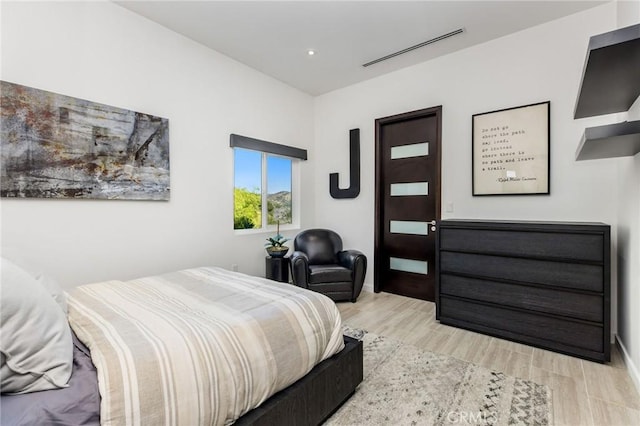 bedroom featuring baseboards, visible vents, and wood finished floors