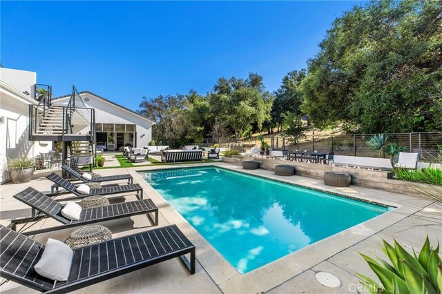 view of swimming pool featuring fence, a patio area, an outdoor living space, and a fenced in pool