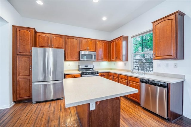 67960 Rio Vista Dr, Cathedral City, CA 92234 - kitchen featuring wood finished floors, appliances with stainless steel finishes, light countertops, a sink, and a center island