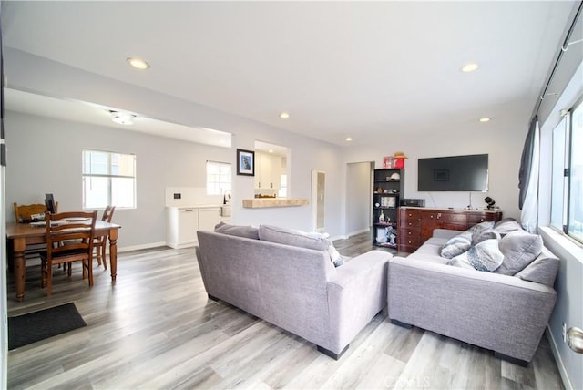 living area with light wood-style floors and recessed lighting