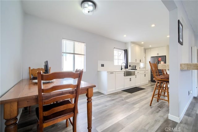 dining space featuring baseboards, recessed lighting, and light wood finished floors