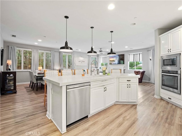 22458 Plantation Ct, Saugus, CA 91350 - kitchen featuring light wood-style floors, light countertops, appliances with stainless steel finishes, and a sink