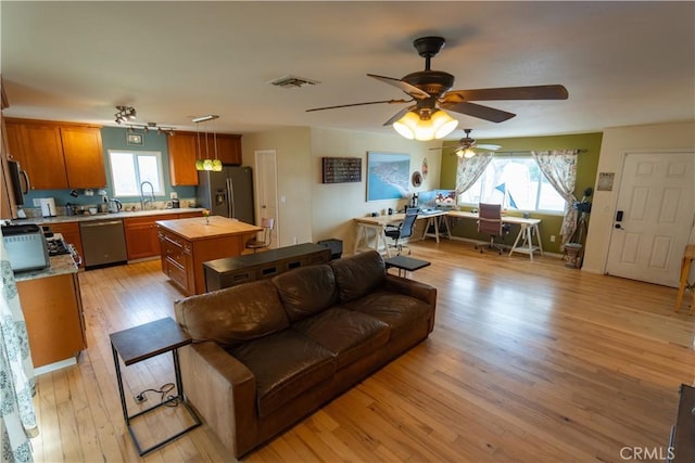 8491 Oak Glen Rd, Cherry Valley, CA 92223 - living room featuring plenty of natural light, light wood finished floors, ceiling fan, and an office area