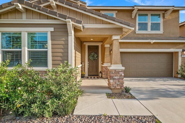 835 Orangedale Ave, Redlands, CA 92374 - view of exterior entry with driveway, stone siding, a garage, and board and batten siding