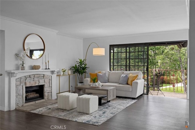 living area featuring wood finished floors, crown molding, and a stone fireplace