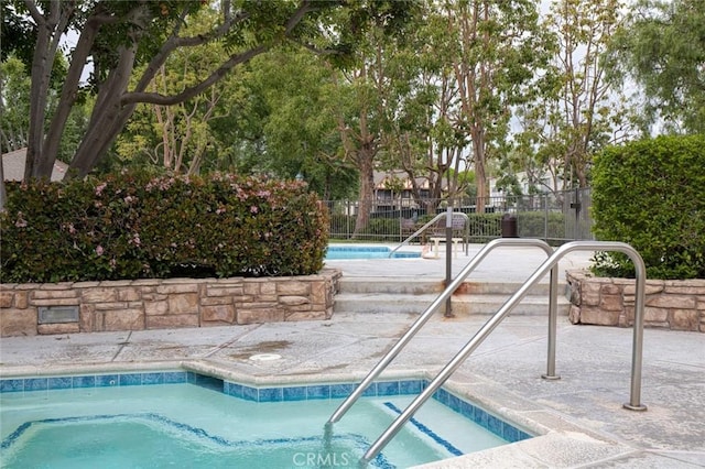 community pool featuring fence and a patio
