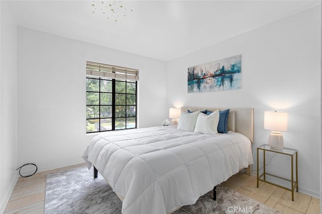 bedroom with light wood-style flooring and baseboards