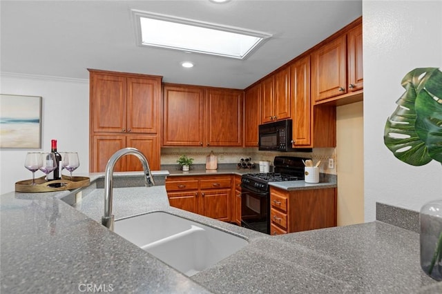 kitchen featuring black appliances, a sink, backsplash, and brown cabinets
