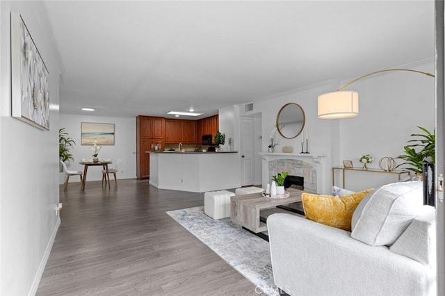 living area featuring recessed lighting, wood finished floors, a fireplace, baseboards, and visible vents