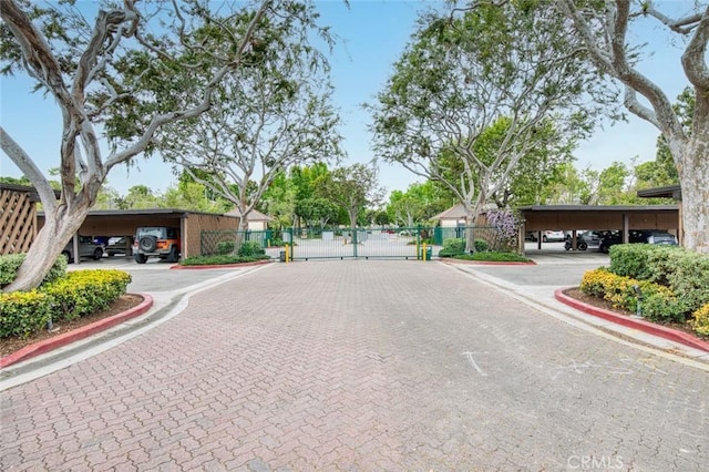 view of road featuring curbs, a gate, and a gated entry