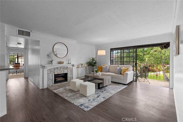 living room featuring a fireplace, wood finished floors, visible vents, and ornamental molding