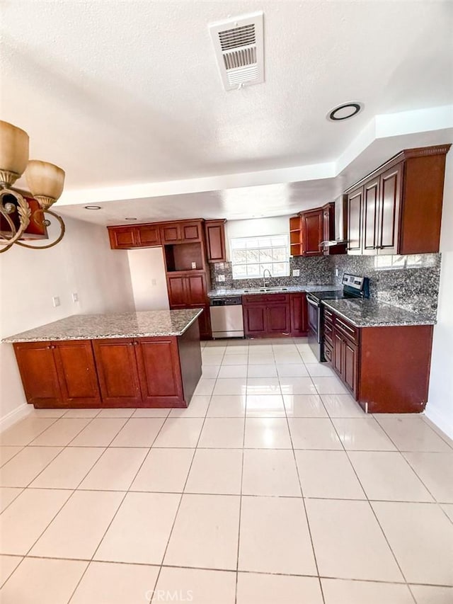 kitchen with dark stone countertops, tasteful backsplash, a sink, visible vents, and stainless steel appliances